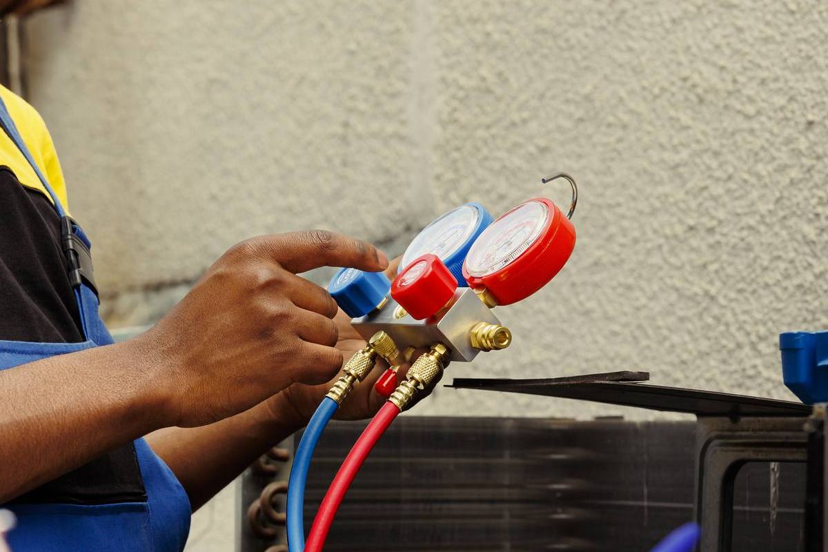 Technicians connecting pressure gauges during an aircon installation