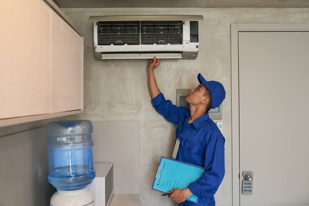 Aircon technician checking a wall-mounted air conditioner
