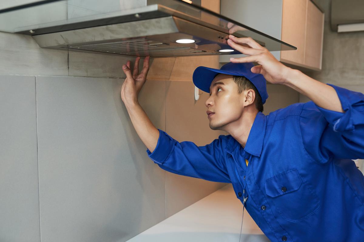 A technician checking a kitchen cooker hood