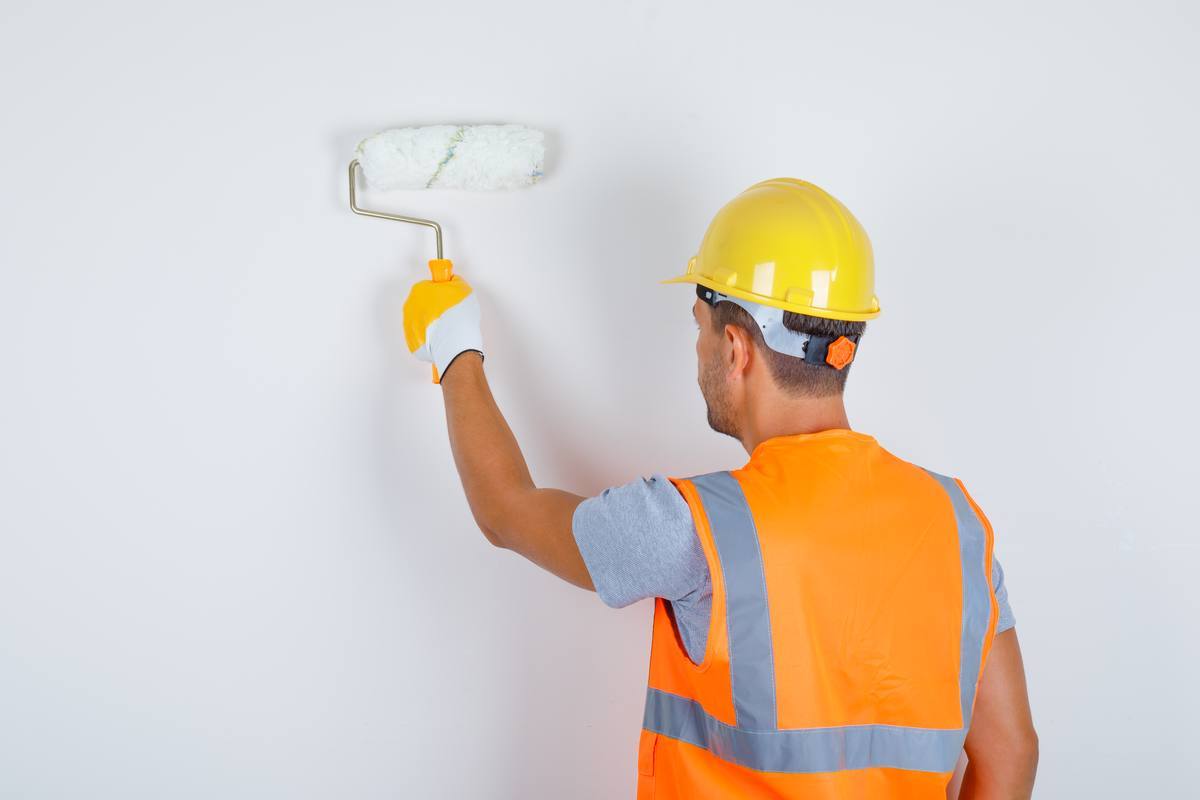 Painter rolling paint onto a wall