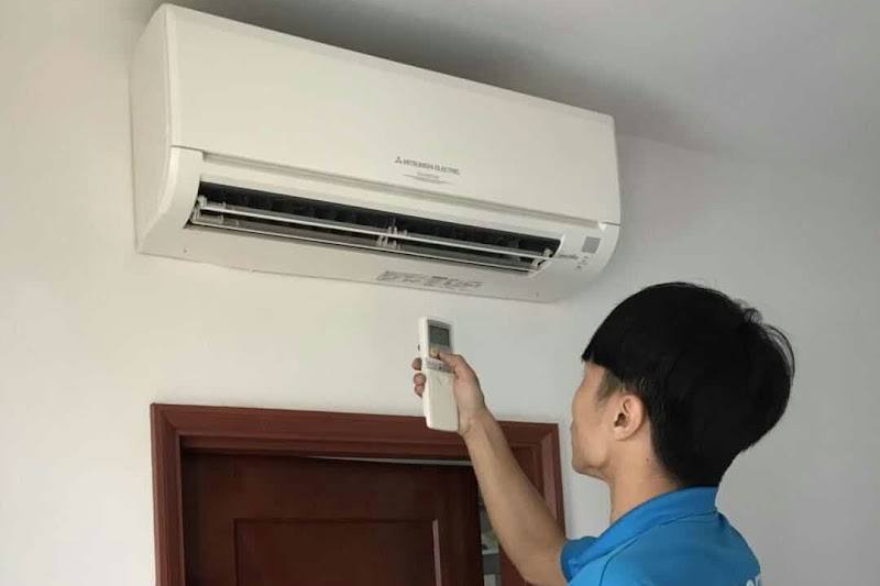 A technician testing a wall-mounted aircon by SoCool