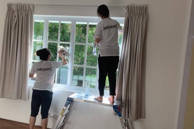Two cleaners wiping windows in a home by Just Clean Lah