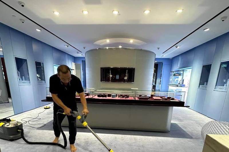 Cleaner shampooing a carpet by Spring Cleaning Services