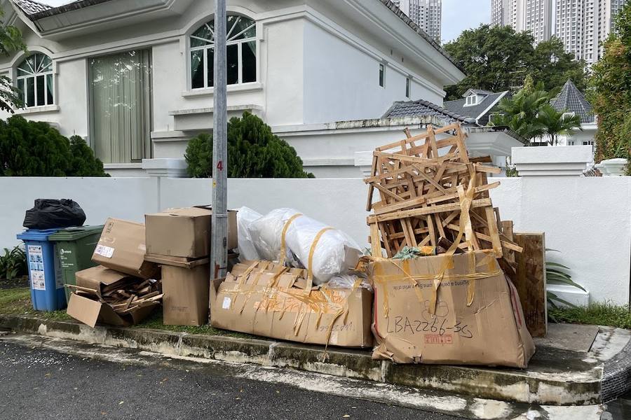 Old furniture and boxes piled outside a landed house for collection by Junk To Clear