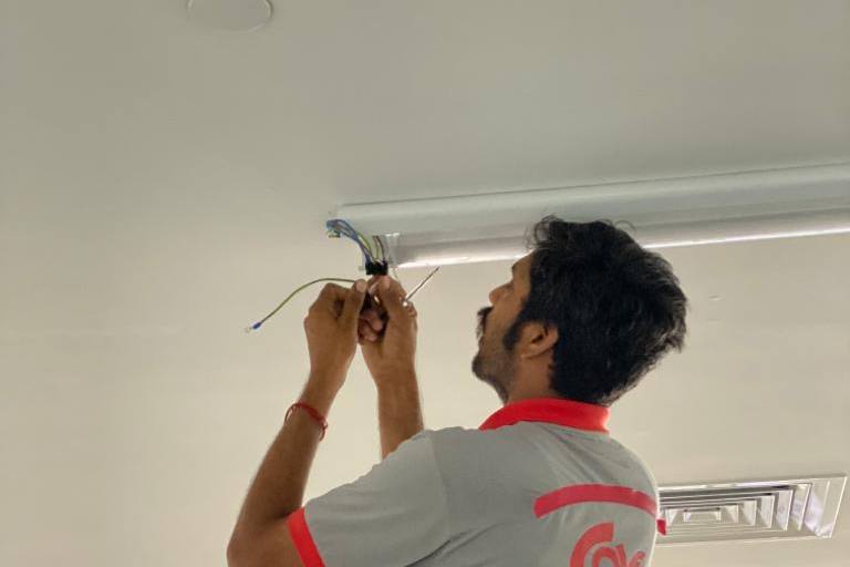 Electrician wiring a ceiling light fitting by AVV Electricals