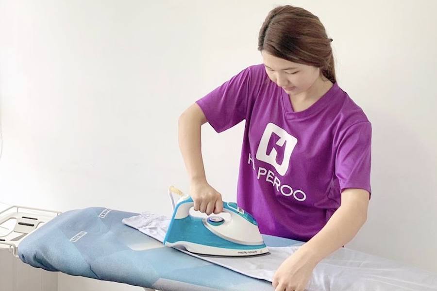 A cleaner ironing clothes by Helperoo