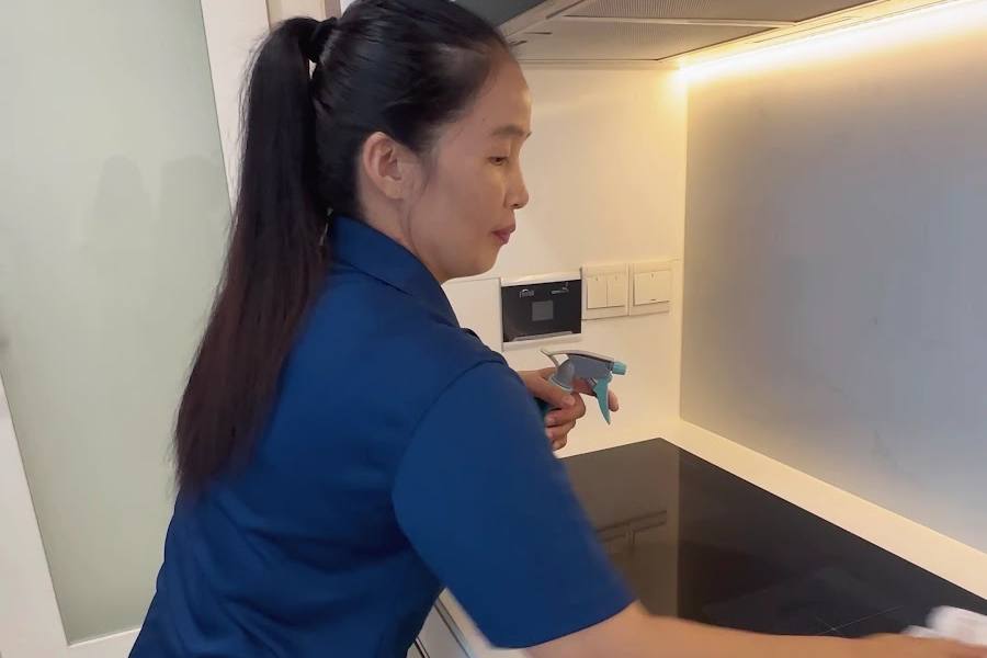 A cleaner wiping a kitchen counter by Home Cleaning SG