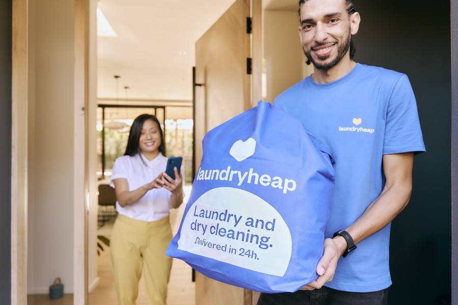Driver handing a laundry bag to a customer by Laundryheap