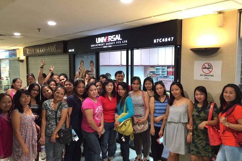 Group photo outside the Lucky Plaza office by Universal Employment Agency