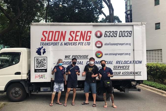 Movers standing beside a branded moving truck by Soon Seng Transport & Movers