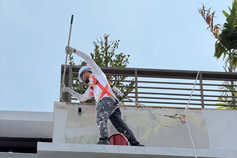 Painter working on an exterior wall of a landed house by CoolBrush Painting and Handyman Service
