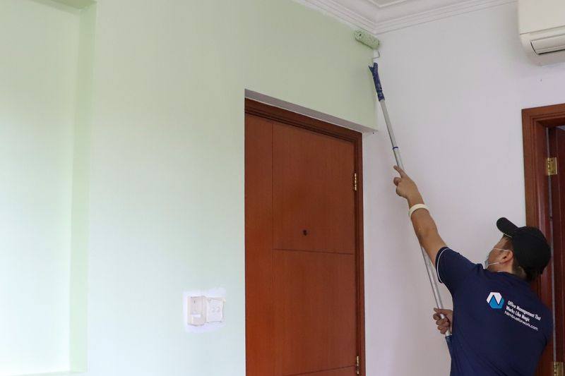 A painter rolling paint onto a wall by Nimbus Homes