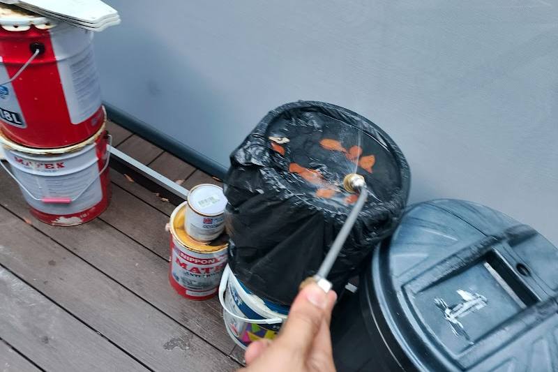 Technician spraying around bins by Ninja Pest Control