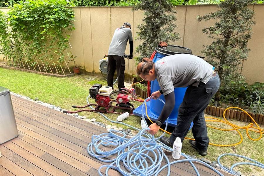 Technicians setting up a spray pump in a garden by Pestopia SG