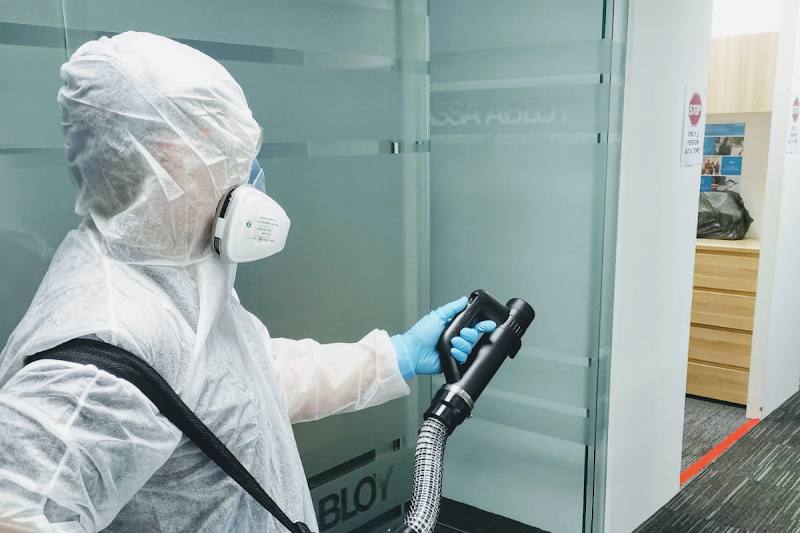 Technician in protective gear fogging an office by The Pest Control Company