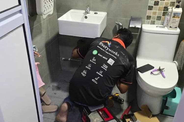 Plumber working under a bathroom basin by Mr Plumber Singapore