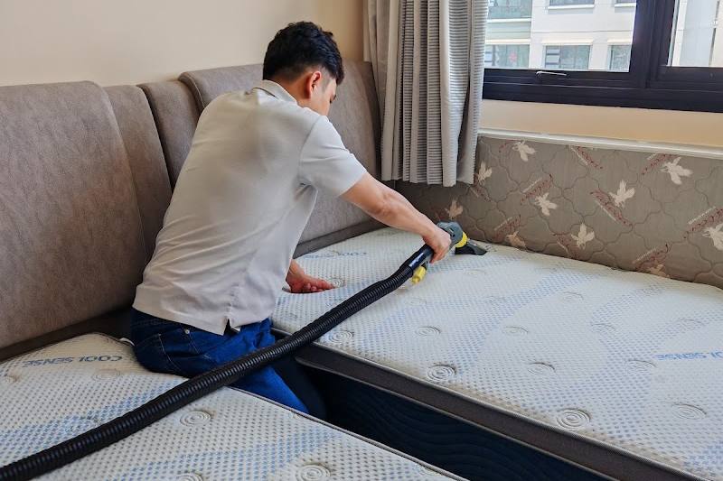 Technician cleaning a mattress with an extraction tool by UltraRevive